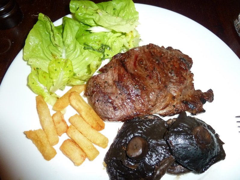 Ribeye steak with salad, field mushrooms and triple-cooked chips
