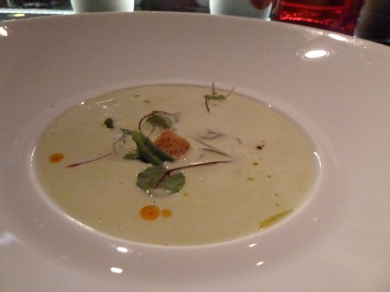 Green asparagus velouté served with goat cheese ravioli